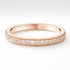 Rose gold ring with diamonds on a light grey background