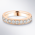 Rose gold ring with diamonds on a light grey background