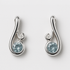 Pair of silver earrings with blue gemstones on a light gray background