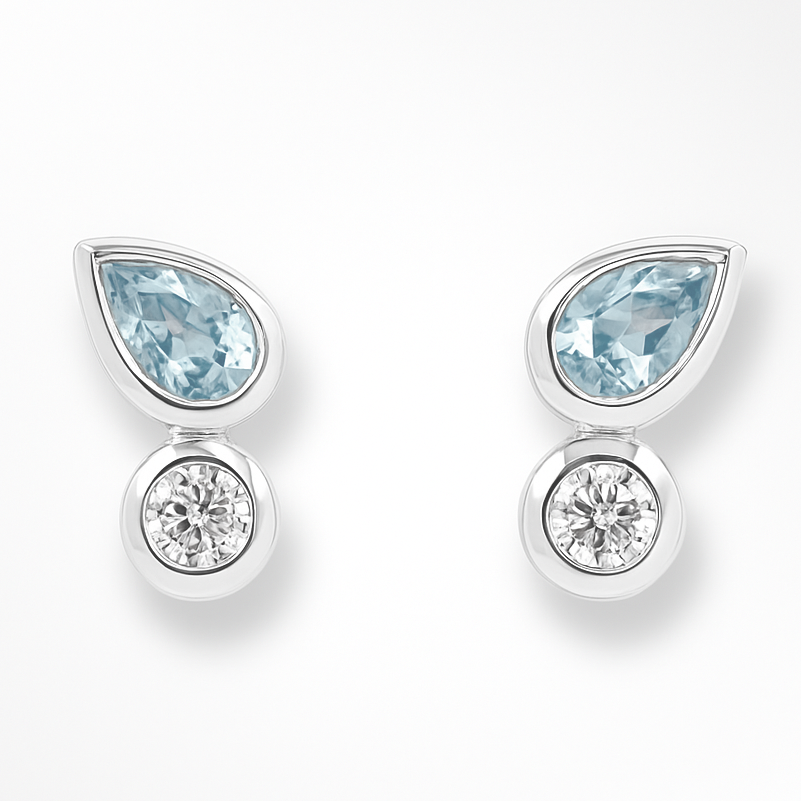 Pair of earrings with teardrop-shaped blue gemstones and round clear gemstones on a white background