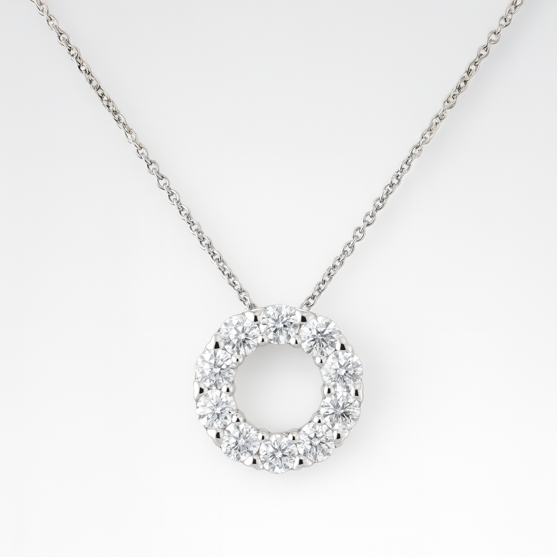 Silver necklace with a round pendant on a white background