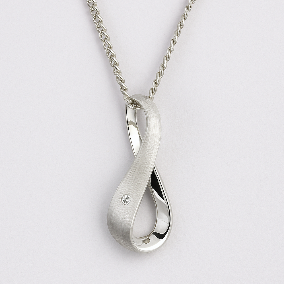 Silver infinity pendant necklace on a light grey background
