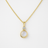 Gold necklace with a pendant featuring a moonstone and small cubic zirconia on a white background