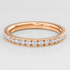 Rose gold ring with diamonds on a light gray background
