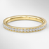 Gold ring with diamonds on a light gray background