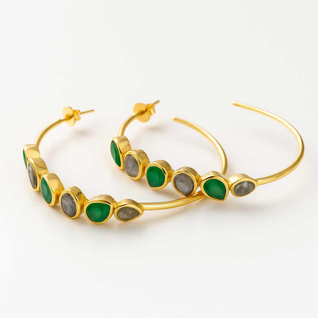 Gold hoop earrings with green and grey stones on a white background