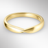 Yellow gold shaped wedding ring on a light grey background